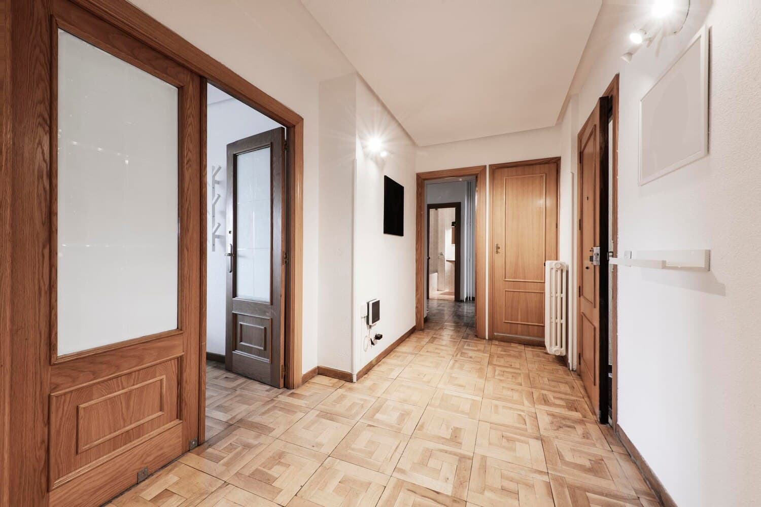 Hallway with wooden doors and parquet flooring