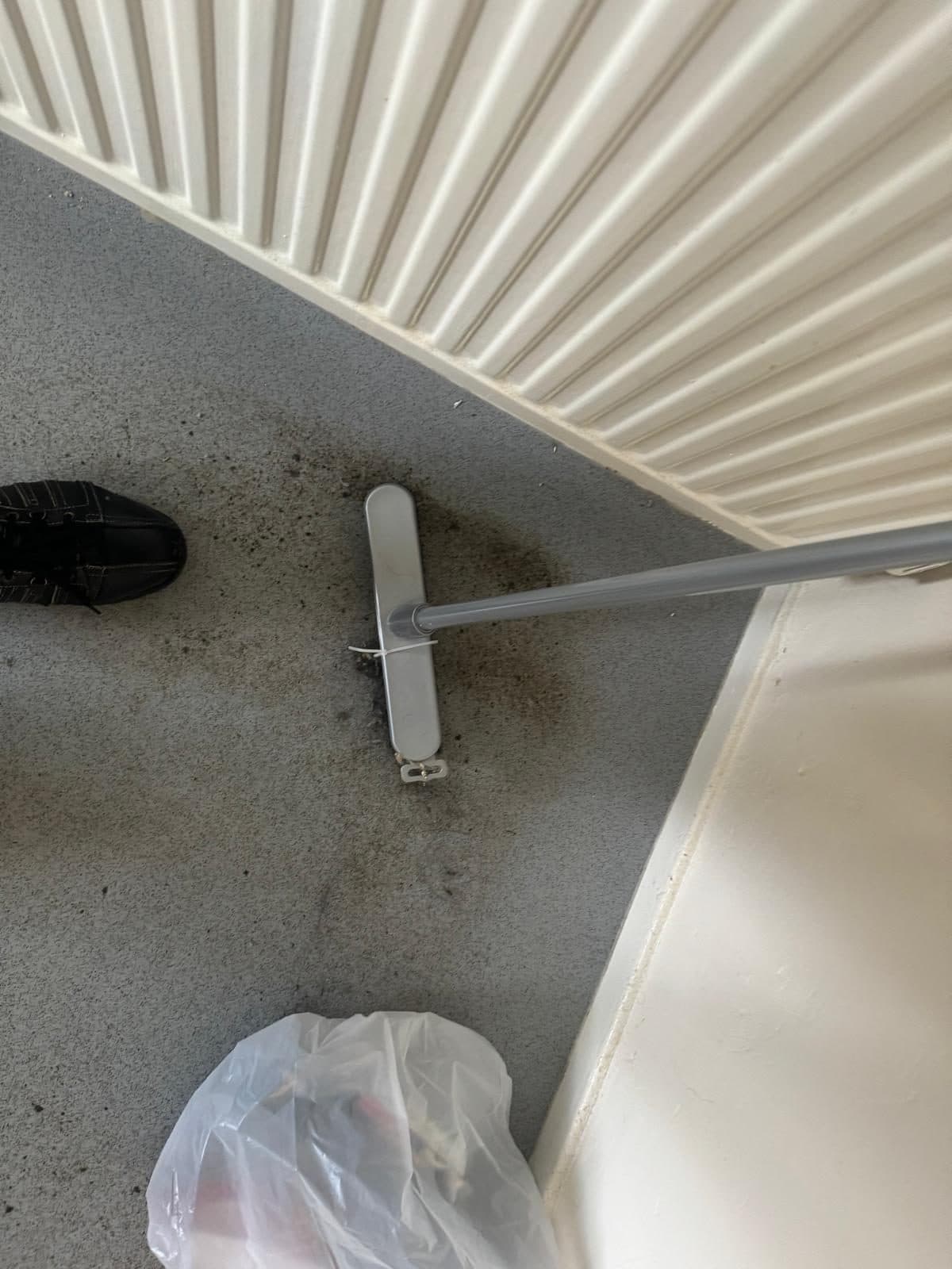 Dirty vinyl floor under a radiator, mid-clean